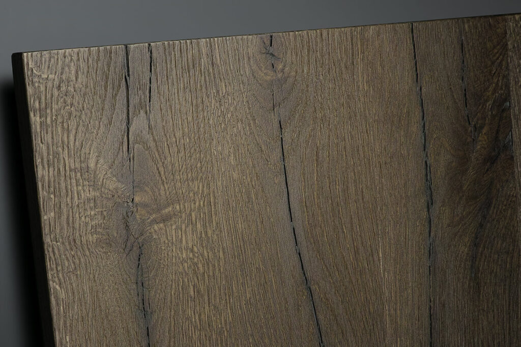 Holzküchen in Dresden: Massivholz, Furnier oder Holzoptik 3 Nahaufnahme einer Dickfurnier-Front von Bauformat in Dark Oak: Maserung mit Ästen und Rissen, links die Kante der Trägerplatte
