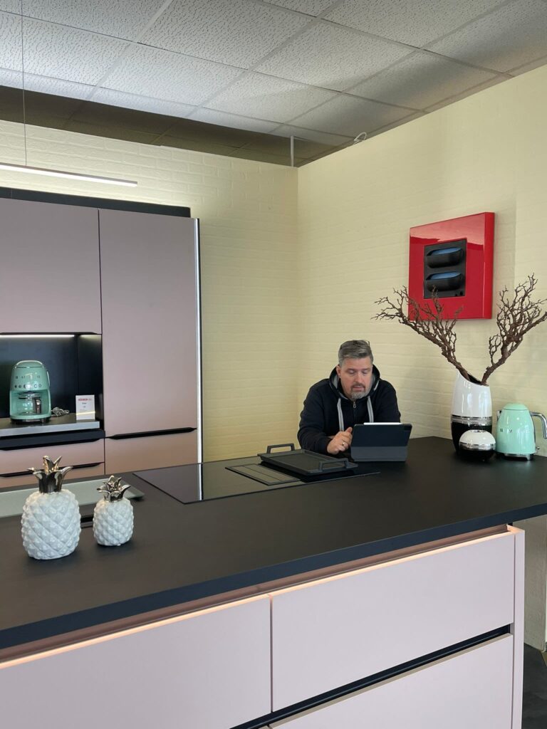 Beratungstresen im Küchen Profi Center Dresden: ein Mitarbeiter arbeitet am Tablet, im Vordergrund eine Küchenarmatur