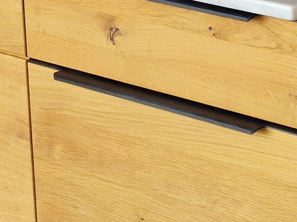 Holzküchen in Dresden: Massivholz, Furnier oder Holzoptik 23 Nahaufnahme der Eichenfronten der Decker-Küche mit Ästen, waagerechter Maserung und schwarzer Griffleiste