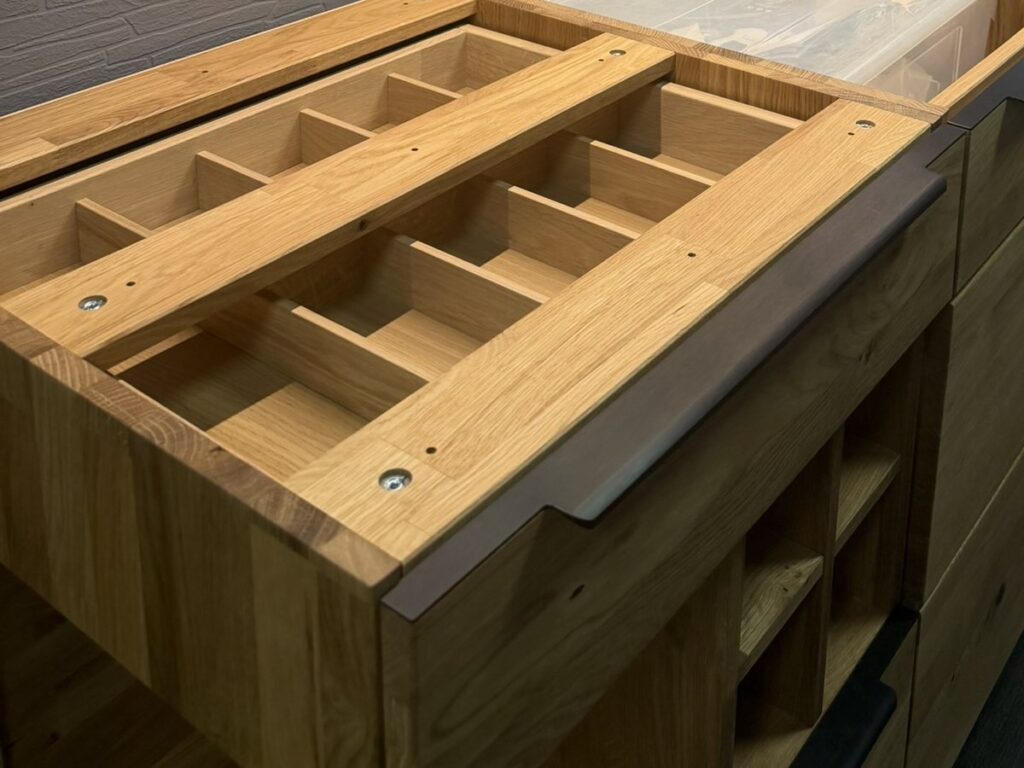 Holzküchen in Dresden: Massivholz, Furnier oder Holzoptik 24 Blick von oben in einen Schubkasten der Decker-Küche mit Besteckeinteilung aus Holz, aufgenommen beim Aufbau der Küche